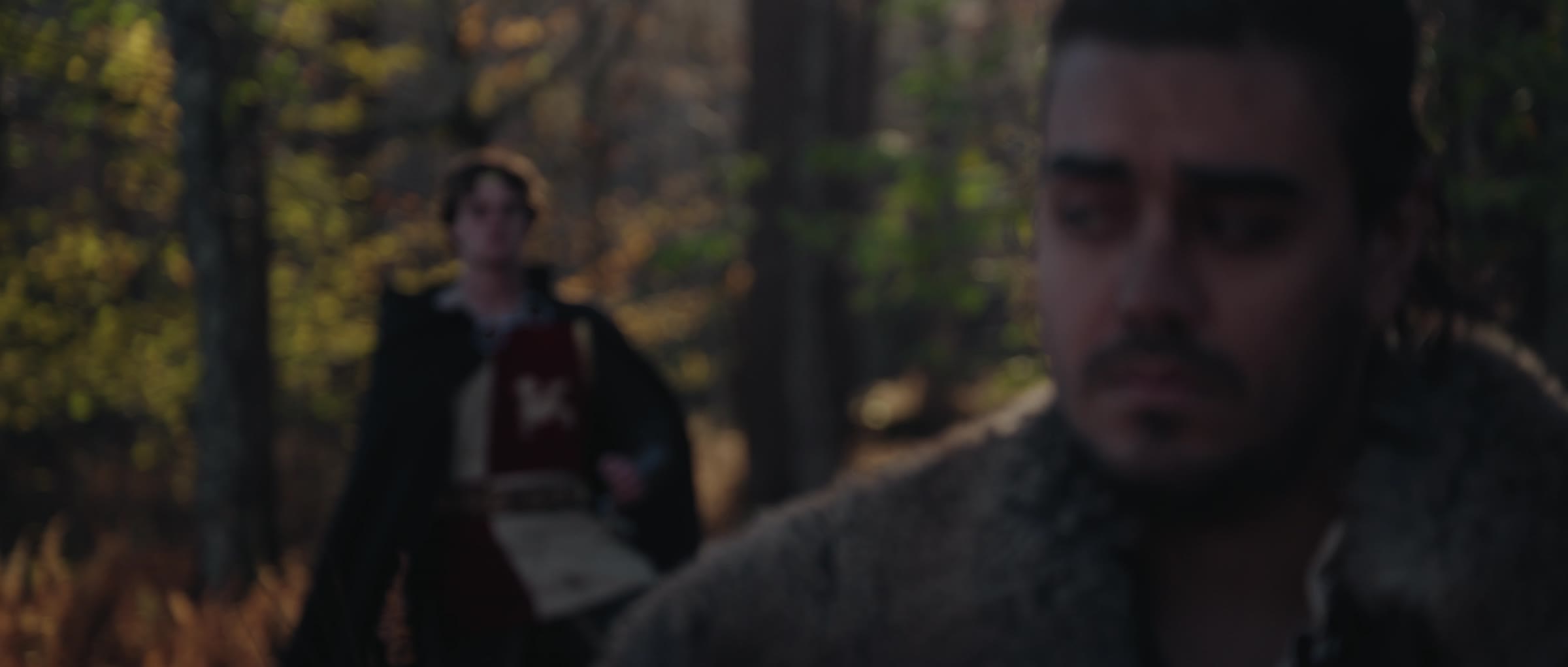 Edmund approaches through the trees as Cynewulf waits