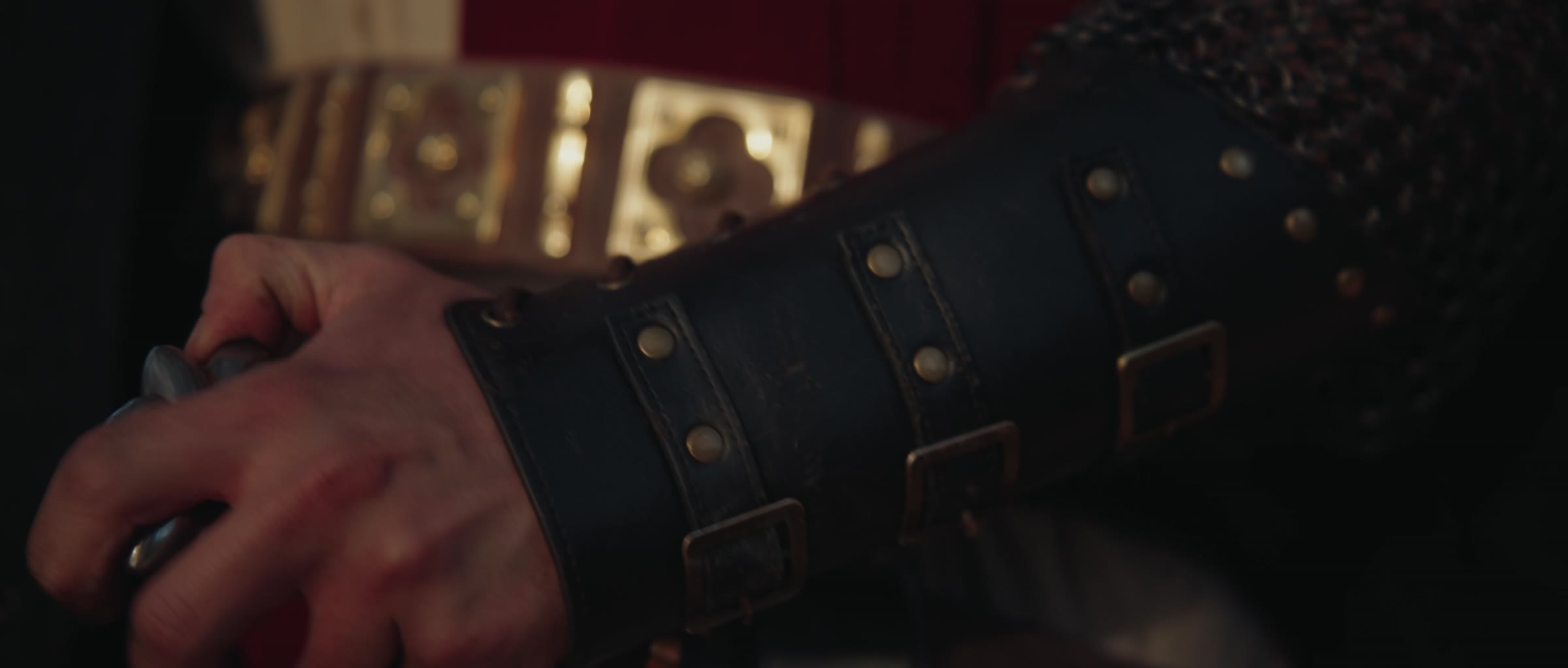 A gauntleted hand grips a sword hilt